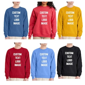 May include: Six long-sleeve crewneck sweatshirts in blue, red, yellow, dark red, light blue, and black. Each sweatshirt features the white text CUSTOM TEXT LOGO IMAGE printed in the center of the chest area, showcasing a simple, solid-colored design.
