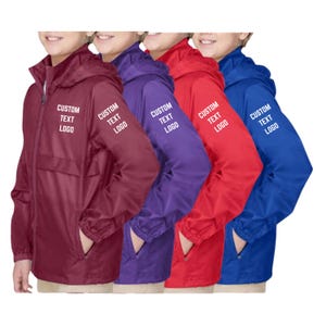 May include: Four lightweight hooded windbreaker jackets in maroon, purple, red, and blue. Each jacket features a full-length front zipper, long sleeves with elastic cuffs, and two front pockets. The text CUSTOM TEXT LOGO is printed on the chest.