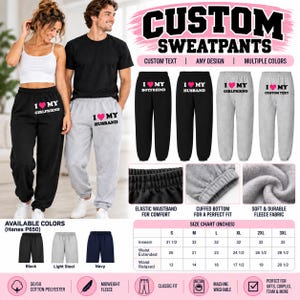 May include: Custom sweatpants featuring a pink heart graphic and text such as I MY HUSBAND or I MY GIRLFRIEND. The sweatpants have an elastic waistband, cuffed bottoms, and are made of fleece fabric. A size chart with measurements in inches is included.