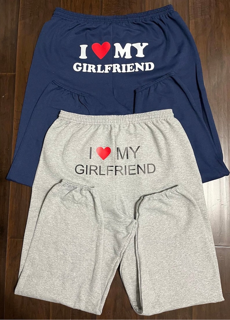 May include: Two pairs of sweatpants, one gray and one navy blue, with the text "I love my girlfriend" printed on the back.