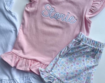 Personlig flickoutfit med rosa fladdrande ärmar | Anpassad broderad namntröja och shorts med blommig volang | Sommarset för baby och småbarn