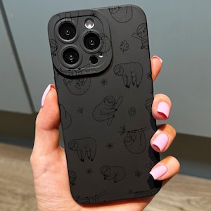 May include: Black phone case featuring a repeating pattern of sloths in various poses. The case has a matte finish and a camera cutout. The sloths are depicted in a simple, line-art style, with small floral accents.