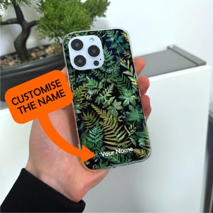 May include: A clear phone case with a green and black fern pattern. The case has a space for a personalized name, which says "Your Name".