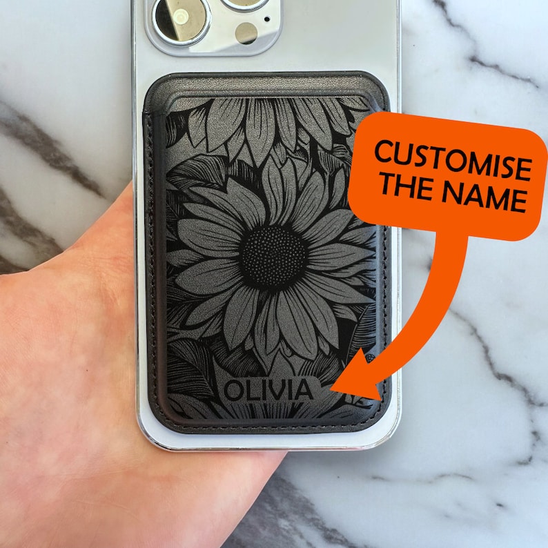 May include: Black leather phone wallet with a sunflower design and the name "Olivia" engraved on it.  Customize the name.