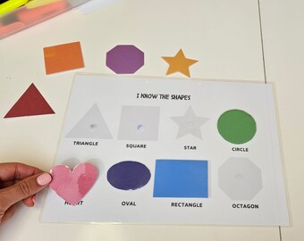 Può includere: Un grafico di apprendimento con diverse forme, tra cui un triangolo, un quadrato, una stella, un cerchio, un cuore, un ovale, un rettangolo e un ottagono. Il grafico ha le parole "I Know The Shapes" in alto.