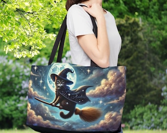 May include: A black tote bag with a whimsical design featuring a black cat wearing a witch's hat and flying on a broomstick in front of a full moon and stars.