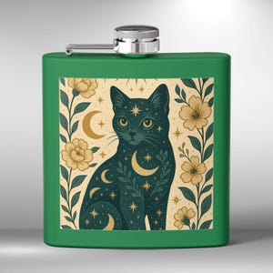Op de afbeelding: Groene metalen fles met een zwarte kat illustratie. De kat is omringd door een bloemmotief met halve manen en sterren.