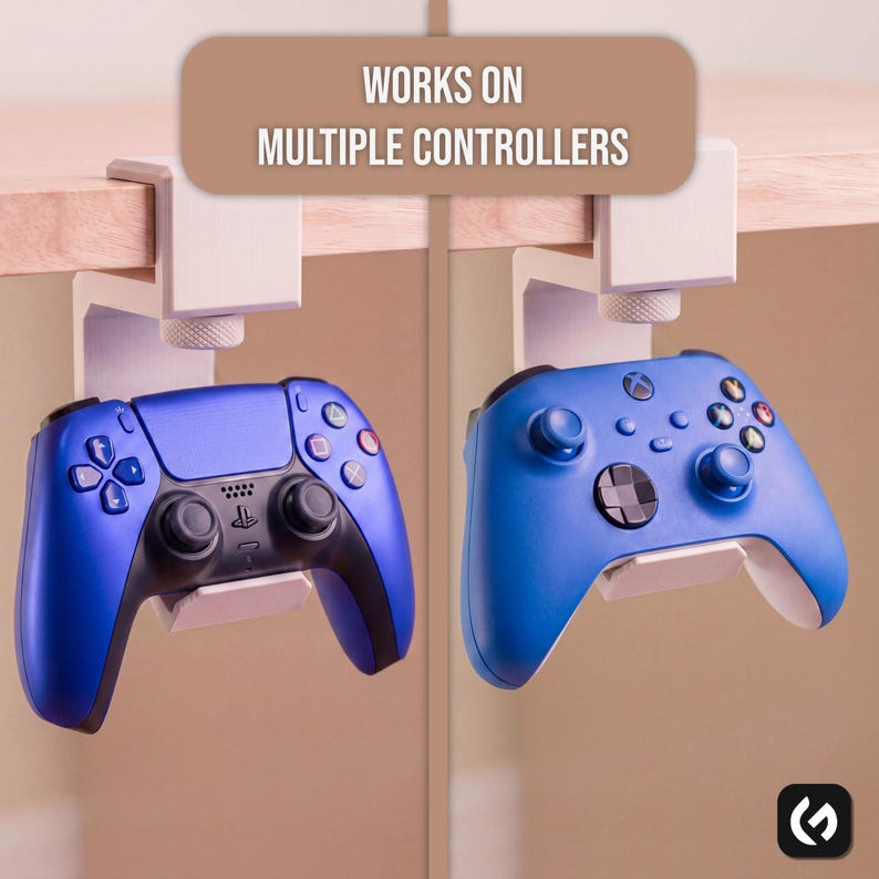 May include: A white under-desk controller mount with a screw-tightening mechanism, holding a blue PlayStation controller on the left and a blue Xbox controller on the right. The text "WORKS ON MULTIPLE CONTROLLERS" is displayed at the top.
