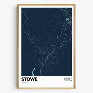 May include: A dark blue map print of Stowe, Vermont with white lines showing the roads and a light blue river. The text "STOWE" and "VERMONT" are at the bottom of the map, along with the coordinates "44.4654° N 72.6878° W".