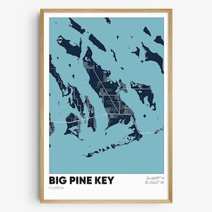 May include: A blue and white map print of Big Pine Key, Florida. The map shows the island's shape and surrounding waters. The text "BIG PINE KEY" and "FLORIDA" are printed below the map, along with the coordinates "24.6699° N 81.3540° W".