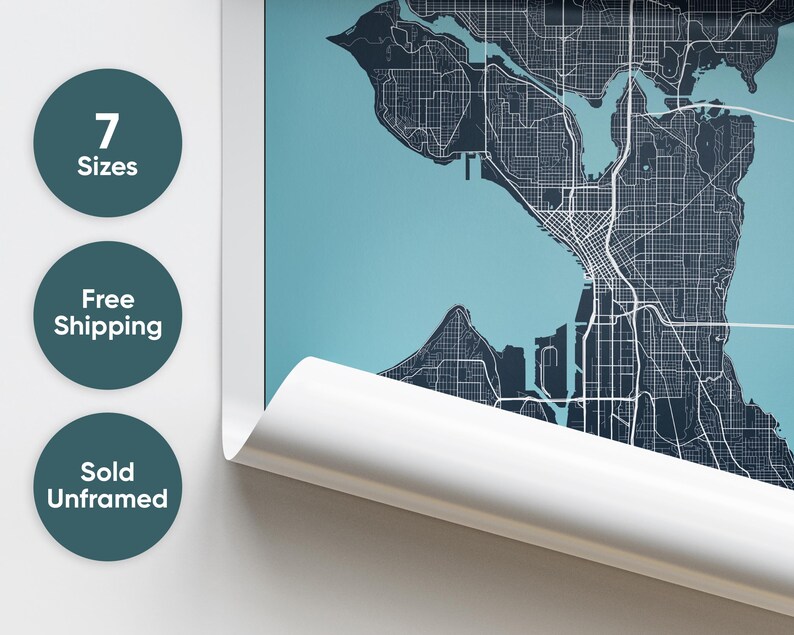 May include: A close-up of a rolled-up poster featuring a detailed map of Seattle, Washington. The map is printed in dark blue and white on a light blue background. The poster is partially unrolled, revealing the city's streets and waterways.