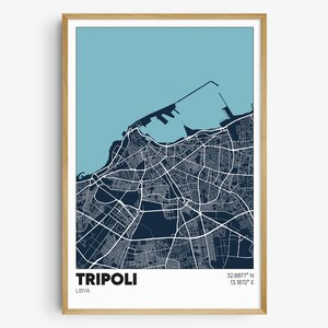 May include: A blue and white map print of Tripoli, Libya. The map shows the city's streets and coastline. The text "TRIPOLI" and "LIBYA" are printed below the map, along with the coordinates "32.8877° N 13.1872° E".