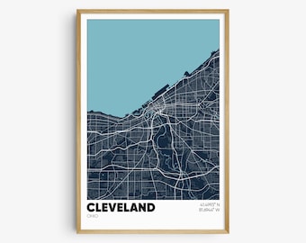 May include: A framed map print of Cleveland, Ohio, featuring a dark navy blue street grid against a light blue water body. The text CLEVELAND, OHIO, and the coordinates 41.4993 N, 81.6944 W are printed in black at the bottom of the white border.