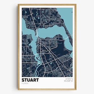 May include: A blue and white map print of Stuart, Florida. The map shows the city's streets, waterways, and landmarks. The text "STUART, FLORIDA" and the coordinates "27.19975° N 80.2528° W" are printed at the bottom of the map.