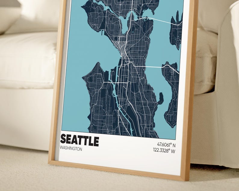 May include: A framed map of Seattle, Washington with a blue background and black lines showing the streets. The map includes the city's name, state, and coordinates: 47.6061&deg; N, 122.3328&deg; W.