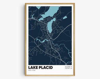 May include: A dark blue map of Lake Placid, New York, with the lake highlighted in light blue. The text "LAKE PLACID" and "NEW YORK" are printed in white at the bottom of the map. The coordinates "44.2795° N 73.9799° W" are printed in white in the bottom right corner.
