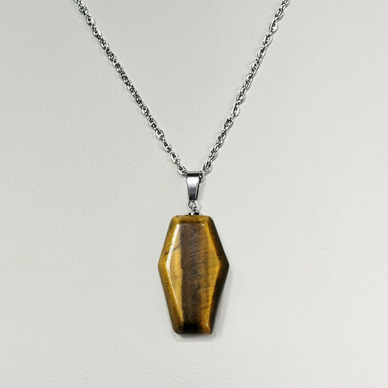 May include: A gold and brown tiger's eye stone pendant on a silver chain necklace.