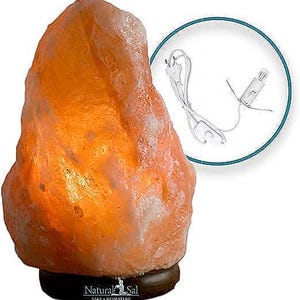 Puede incluir: L&aacute;mpara de sal del Himalaya con una combinaci&oacute;n de colores naranja y blanco. La l&aacute;mpara est&aacute; sobre una base marr&oacute;n oscuro e incluye un cable de alimentaci&oacute;n y una bombilla. La l&aacute;mpara tiene el texto "Natural Sal" en la base.