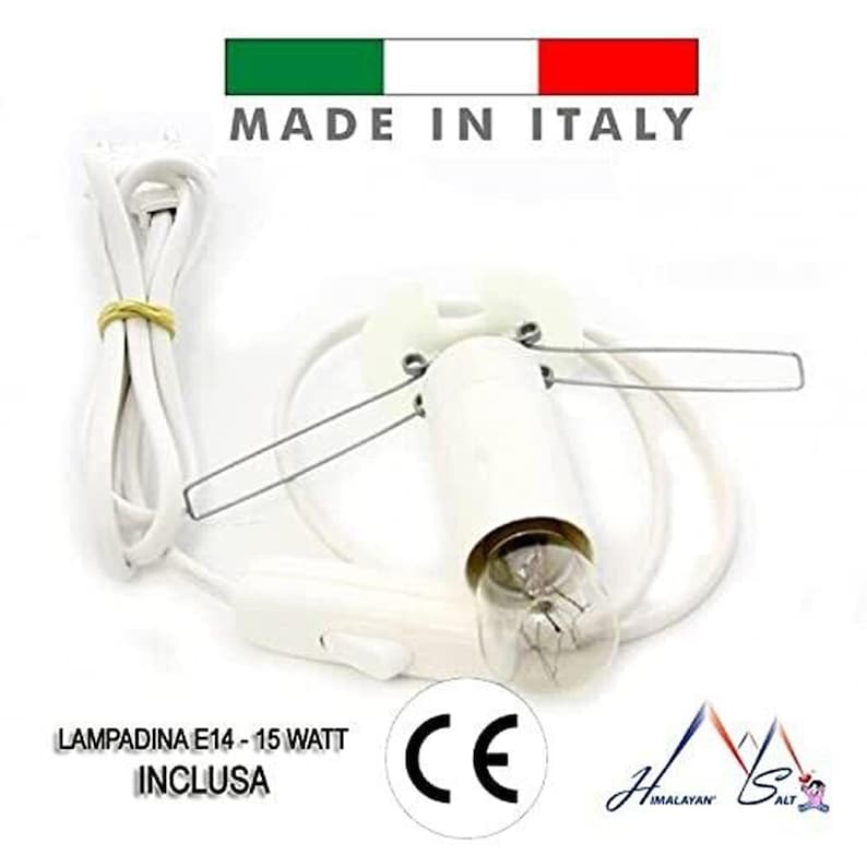 Puede incluir: Un portal&aacute;mparas blanco con una bombilla transparente, cable e interruptor de encendido/apagado. El texto "MADE IN ITALY" est&aacute; en la parte superior y "LAMPADINA E14 - 15 WATT INCLUSA" en la parte inferior. Tambi&eacute;n se ve una marca CE.