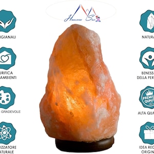 Puede incluir: L&aacute;mpara de sal del Himalaya con una superficie rugosa de color naranja-rosa. La l&aacute;mpara se asienta sobre una base marr&oacute;n oscuro. El texto en la imagen incluye "Himalayan Salt", "Artigianali", "Purifica Gli Ambienti", "Luce Gradevole", "Ionizzatore Naturale", "Naturali", "Benessere Della Persona", "Alta Qualita'" e "Idea Regalo Originale".