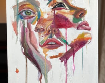 May include: An abstract painting of a face with a green eye, rendered in a vibrant palette of colors. The artwork features bold brushstrokes and a unique, expressive style, with paint drips adding to the artistic effect. The canvas is mounted on a wooden easel.