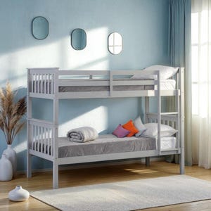 May include: A light gray wooden bunk bed featuring a slatted headboard and footboard design on both levels, an integrated vertical ladder, and two mattresses dressed in gray bedding with a folded gray blanket and three small decorative pillows.