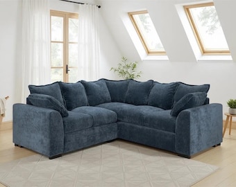 Sofá de canto Colbee: Sofá grande em formato de L, revestido em tecido azul, moderno e espaçoso para sala de estar familiar.