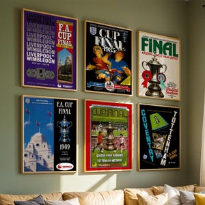 May include: A selection of framed vintage football posters, with bold typography and vibrant colours. The posters display match details, team names, and the FA Cup Final. The artwork includes images of trophies and action shots from the games.
