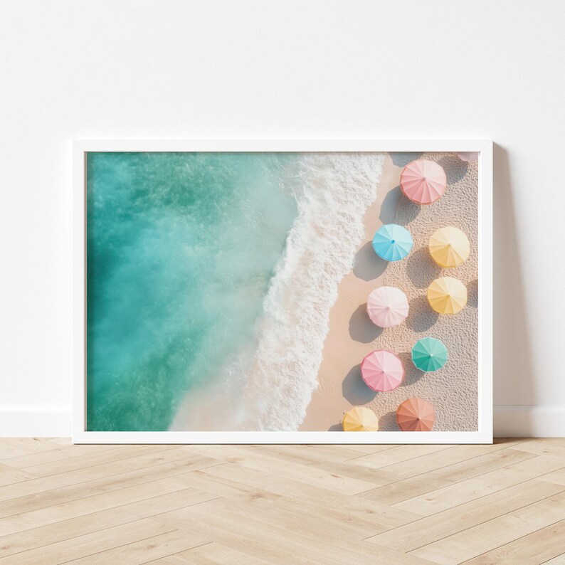 May include: An aerial view of a sandy beach with turquoise water and a row of colorful umbrellas in pastel shades of pink, blue, yellow, and green.