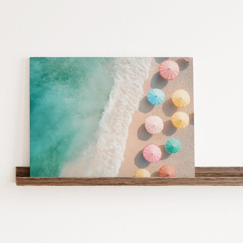 May include: An aerial view of a sandy beach with turquoise water and a row of colorful umbrellas in pastel shades of pink, blue, yellow, and green.