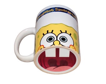 Taza amarilla de porcelana con cara de dibujos animados de 300 ml y estampado oculto