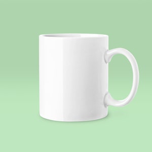 May include: A white ceramic mug with a rounded handle. The mug is empty and has a smooth, glossy finish.