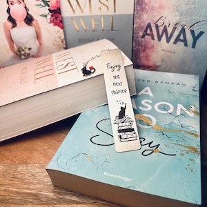 Könnte beinhalten: Ein Holz-Lesezeichen mit einer schwarzen Katze, die auf einem Stapel Bücher sitzt. Das Lesezeichen lautet "Enjoy the next chapter".