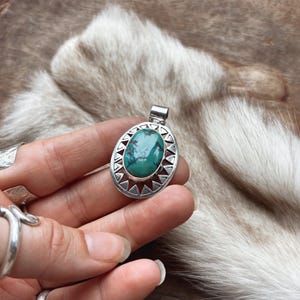 Precioso colgante de plata de ley 925 con turquesa, diseño de rayos de sol y forma de onda calada.