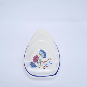 May include: White ceramic bread knife holder with a blue and pink floral design.