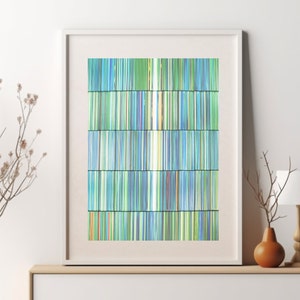 May include: Abstract art print featuring a vertical design of thin, colourful lines in shades of blue, green, and white. The lines are arranged in a grid pattern, creating a sense of depth and movement.