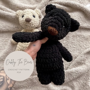 May include: A crochet pattern for Oakley the Bear, a black and white crocheted stuffed animal. The pattern is available as a PDF download.