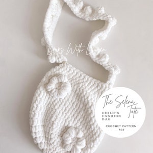 May include: White crocheted tote bag with a flower design and a long strap. The bag is labeled "The Selena Tote Child's Fashion Bag Crochet Pattern PDF".