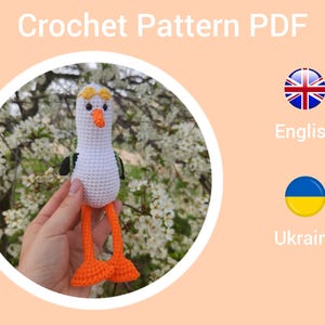 May include: Crochet pattern PDF for a white stork amigurumi with orange legs and a yellow beak. The pattern is available in English and Ukrainian.