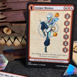 May include: A trading card featuring a character named Juniper Nimbus. The card has a detailed illustration of a blue-skinned figure in a dynamic pose, holding bells. Text includes character stats and the quote, "The braiding is for focus. The bruises are incidental."
