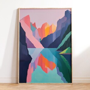 May include: A framed abstract painting of a mountain range reflected in a lake. The mountains are a mix of pink, purple, blue, and green, with a bright orange sunset in the background. The lake is a turquoise blue with a reflection of the mountains.