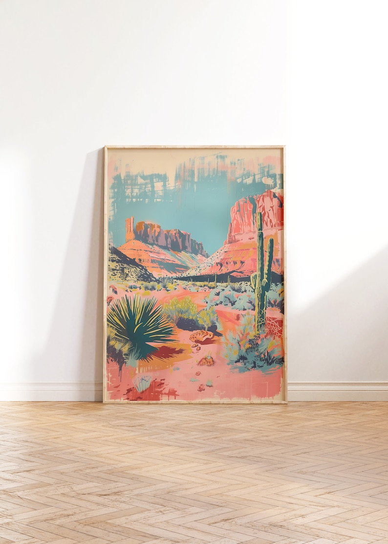 May include: A framed print depicting a desert landscape with red rock formations, cacti, and various desert plants. The print is in a light wood frame and has a vintage aesthetic.