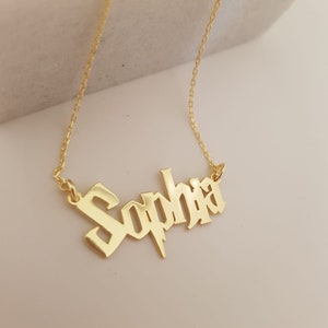 Puede incluir: Collar de oro con el nombre "Sophia" en fuente g&oacute;tica con un dise&ntilde;o de rayo.