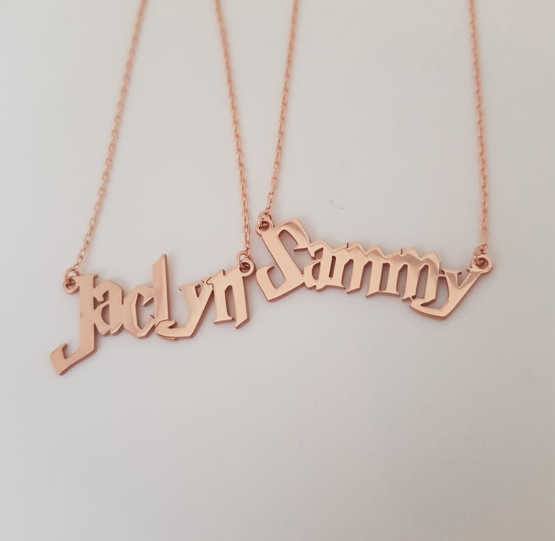 Puede incluir: Dos collares de oro con los nombres "Jaclyn" y "Sammy" escritos en letra g&oacute;tica.