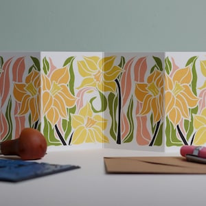 Daffodil botanical Garland card shown fully extended (105 x 297mm), displaying complete hand-carved linocut design. Modern cottagecore daffodil  portrait in pink, green and yellow, perfect for mantlepiece display.