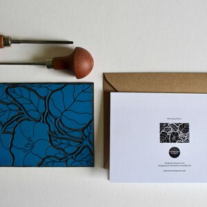 May include: A blue linoleum block print of a floral design with the text "Morning Glory" on the back of the card. The card is in a brown envelope.