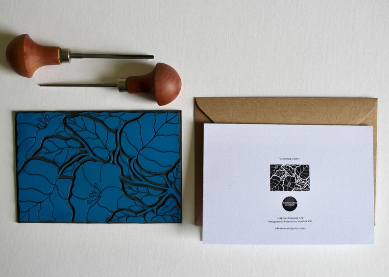 May include: A blue linoleum block print of a floral design with the text "Morning Glory" on the back of the card. The card is in a brown envelope.