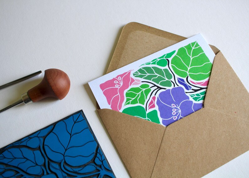 May include: A handmade greeting card with a floral design featuring pink, purple, and green flowers and leaves. The card is in a brown envelope.