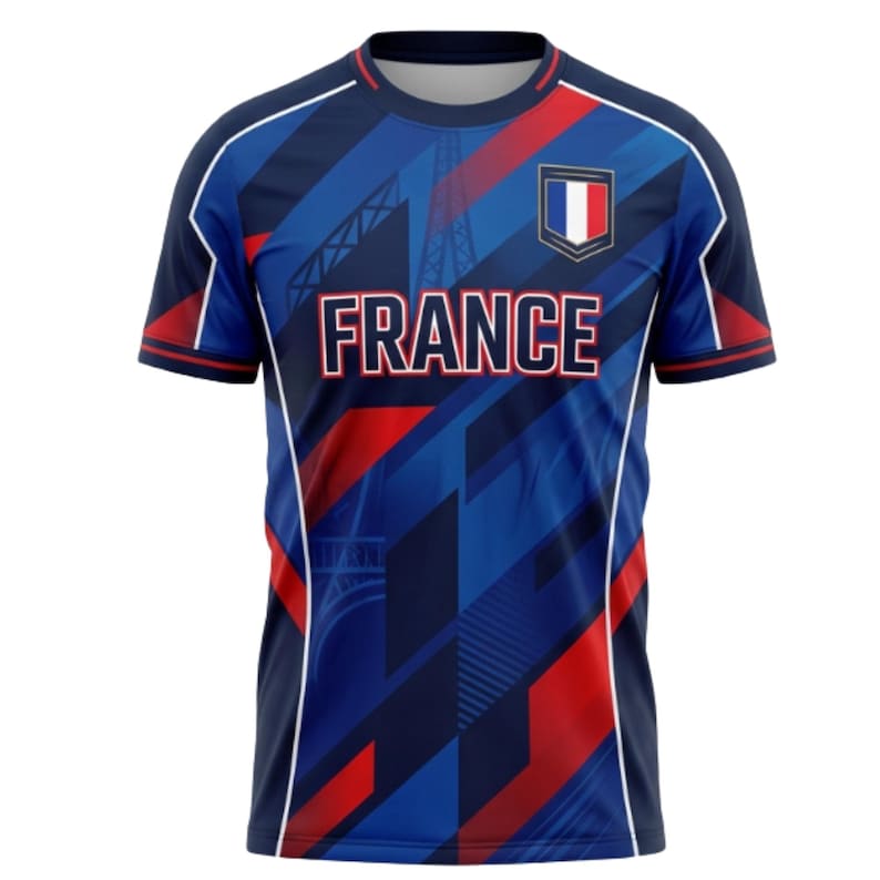 Op de afbeelding: Blauw shirt met korte mouwen met een geometrisch ontwerp in rood en marineblauw. Het woord "FRANCE" staat in witte blokletters over de borst. Een klein Frans vlagembleem staat rechtsboven.