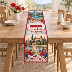 Puede incluir: Un camino de mesa acolchado rectangular con un paisaje de montañas, un lago y un castillo. El diseño incluye amapolas rojas, acianos azules y margaritas blancas. Un panel central blanco muestra el texto Your Text.